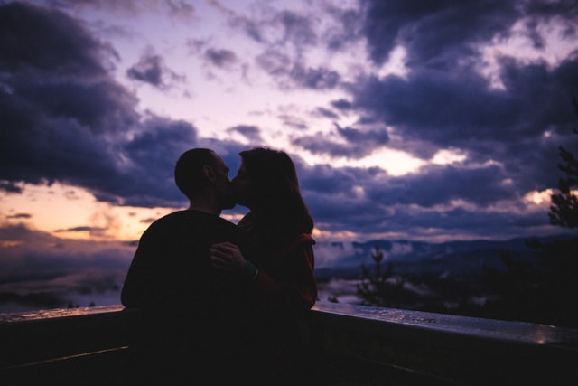 Joli couple s'embrassant au coucher du soleil.